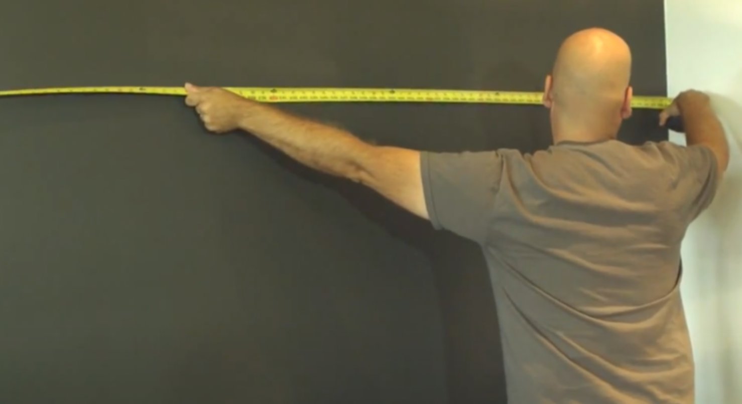 Man Measuring a Wall